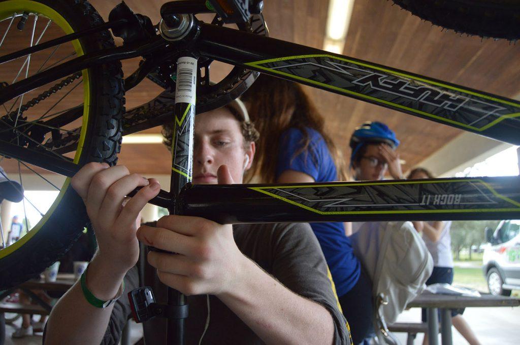 Sophomore Christopher McCormick works on his bike during the sophomore class activities on Nov. 13 at C.B. Smith Park.  The bikes were donated to Toys for Tots.  Afterwards, the class played a variety of games and engaged in team-building activities.  Photo by Pedro Schmeil.