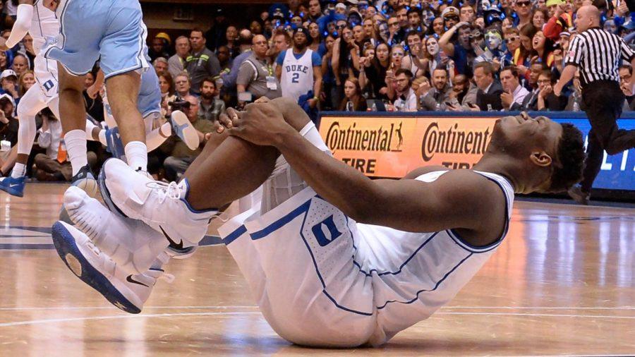 Duke forward Zion Williamson holds his knee after injuring himself and damaging his shoe during the opening moments of the game in the first half on Wednesday, Feb. 20, 2019, at Cameron Indoor Stadium in Durham, N.C. (Chuck Liddy/Raleigh News & Observer/TNS)