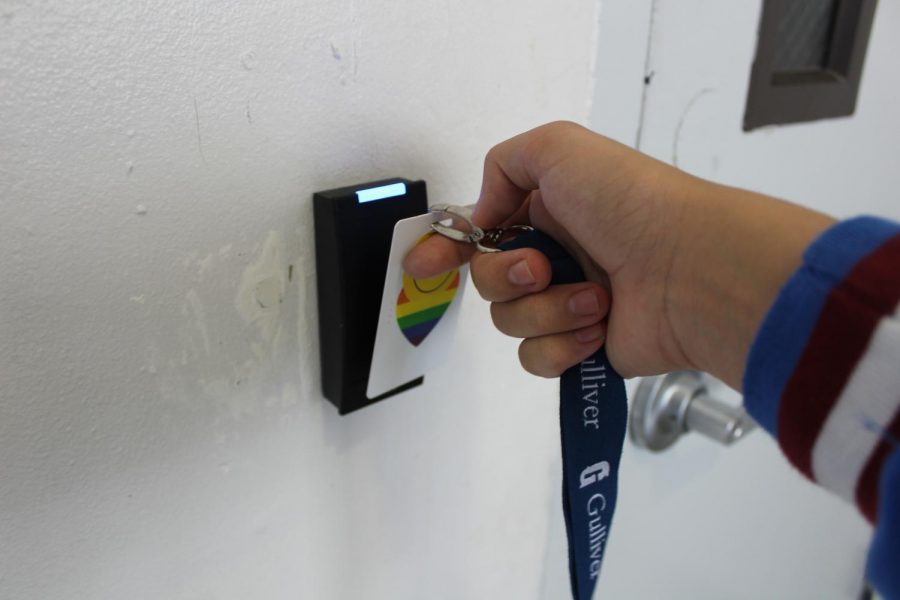 Student holds up their ID to the new scanners in order to enter into the protected areas. After the valid ID is scanned the scanner turns green and then flashes blue while the door is unlocked. 