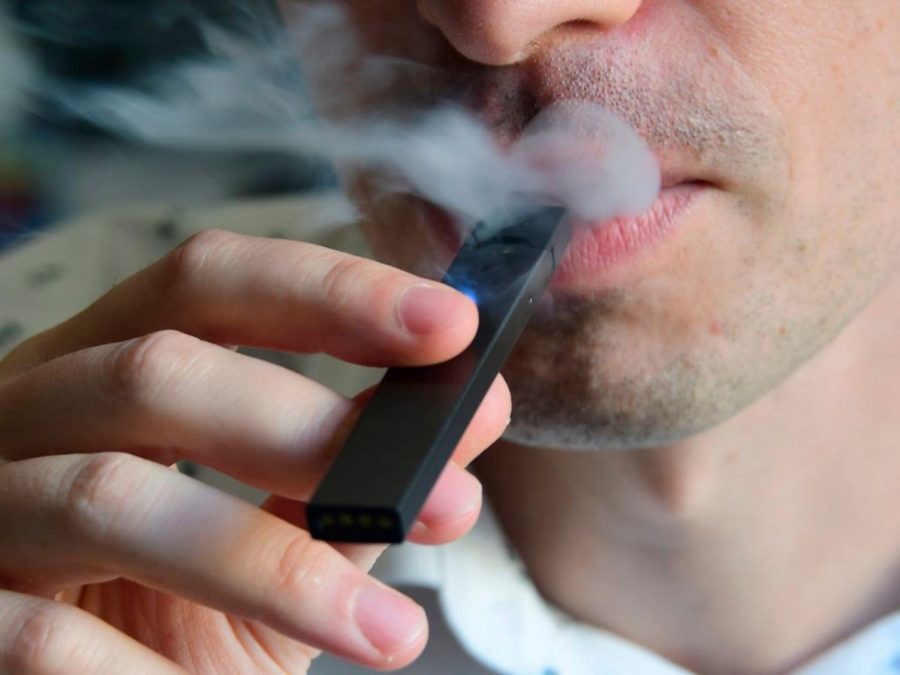 An illustration shows a man exhaling smoke from an electronic cigarette in Washington, DC on October 2, 2018. - In just three years, the electronic cigarette manufacturer Juul has swallowed the American market with its vaporettes in the shape of a USB key. Its success represents a public health dilemma for health authorities in the United States and elsewhere. (EVA HAMBACH/AFP/Getty Images/TNS) *FOR USE WITH THIS STORY ONLY*