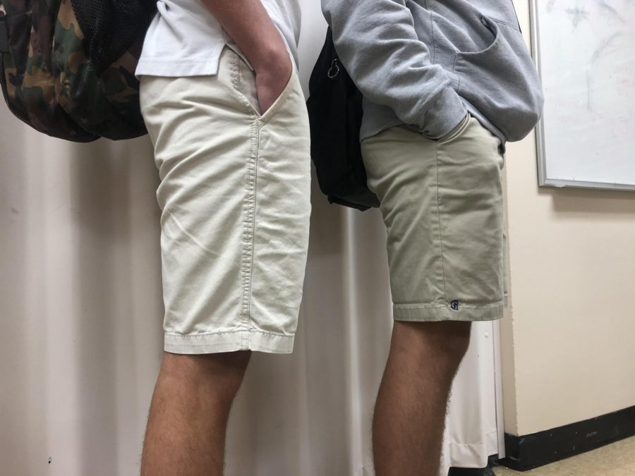Students stand side by side wearing variations of uniform pants. These two boys demonstrate the differences between what many others wear to school and the traditional AA pants. 