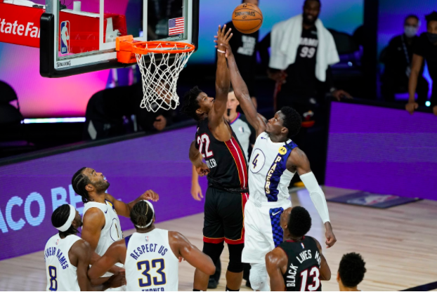 Jimmy Butler #22 of the Miami Heat and Victor Oladipo #4 of the Indiana Pacers battle for a rebound during the second half of a first round playoff game at The Field House at ESPN Wide World Of Sports Complex on Aug. 24, 2020 in Lake Buena Vista, Florida. The Heat beat the Pacers 99-87. (Ashley Landis-Pool/Getty Images/TNS)