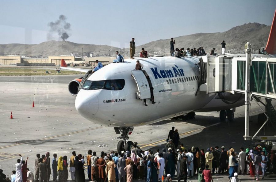 Afghan+people+climb+atop+a+plane+as+they+wait+at+the+Kabul+airport+in+Kabul%2C+Afghanistan%2C+on+Aug.+16%2C+2021.