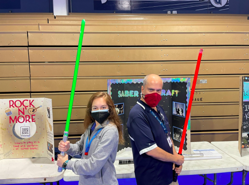Senior Caroline Isom, president of the new Saber Craft Choreography Club,  wields her lightsaber with anthropology teacher Mario Cubas, one of the clubs sponsors.