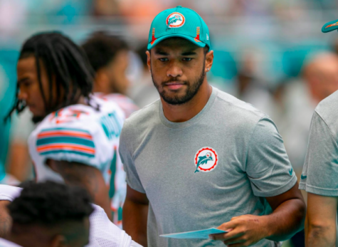 injured Miami Dolphins quarterback Tua Tagovailoa greets teammates before the start of a game against the Indianapolis Colts on Oct. 3, 2021, at Hard Rock Stadium in Miami Gardens, Florida.