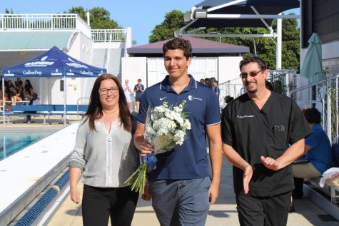 Senior Parker Rosenthal walks with his parents during the boys water polo Senior Day ceremony.