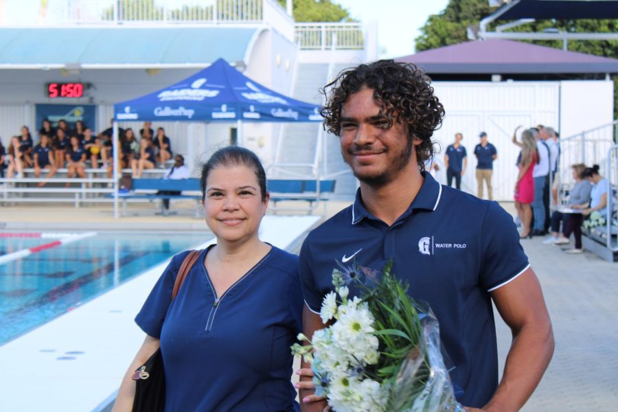 Senior Nick Aday walks with his mother during the boys water polo Senior Day ceremony.