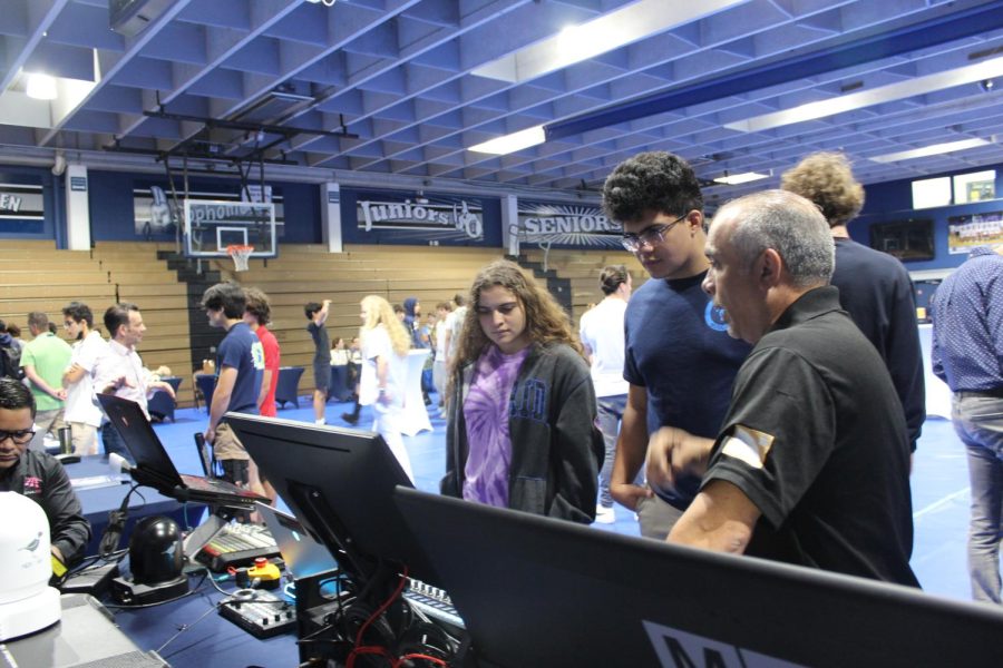 Seniors Daymara Nieves and Luca Chaia visit a booth at the Career Fair on Apr. 13 