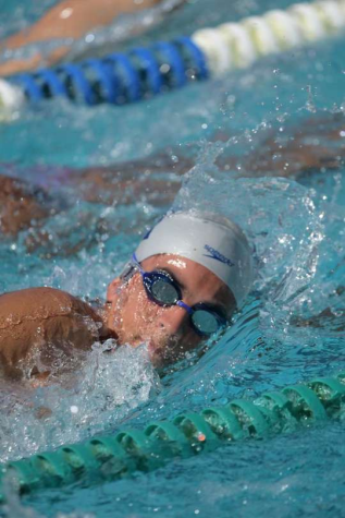 One of the boys swimming team members competing in a relay race.