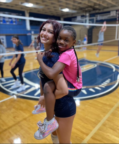 Junior Maya Pace poses with one of the children who are apart of the program. The activities took place in the gym from 2:00 to 5:00 pm. 