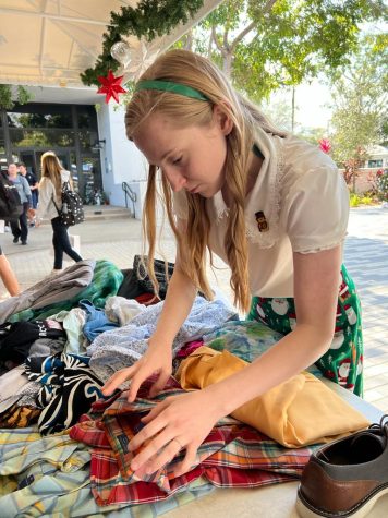 Senior Ainsley Kling organizes clothing by type on the table. The Environmental Club was able to raise $176 for Lotus House and donated the unsold clothing to Lauren’s Kids. The event was held to promote sustainability on campus.