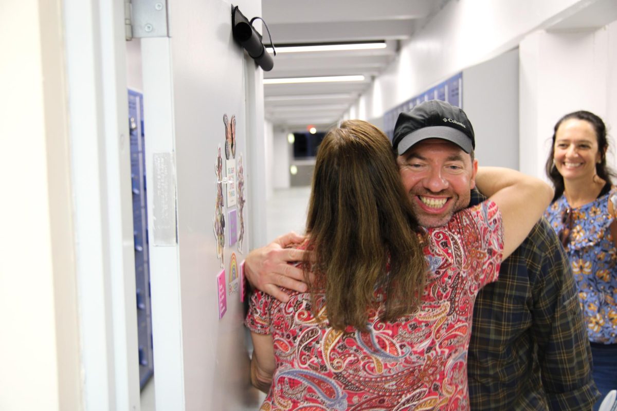 Art teacher Maribel Toledo hugs her student’s father, welcoming him into her class.