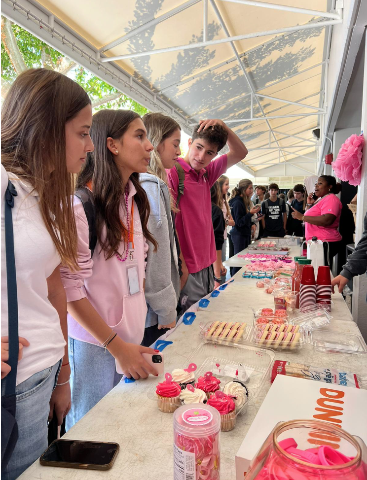 Students gather around the baked goods table ready to purchase a treat. Options included lollipops, cookies, lemonade, homemade baked goods and more. All of the items stuck to the Pink Party theme.