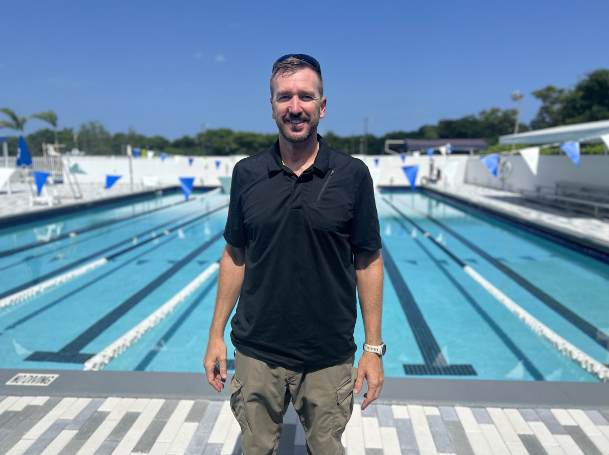 Coach Folker stands in front of the MCK Campus pool before the start of the season. Due to the Upper Schools pool construction, the Varsity team had to practice at the MCK campus for a month. The Raiders are now back at the Upper School practicing everyday.