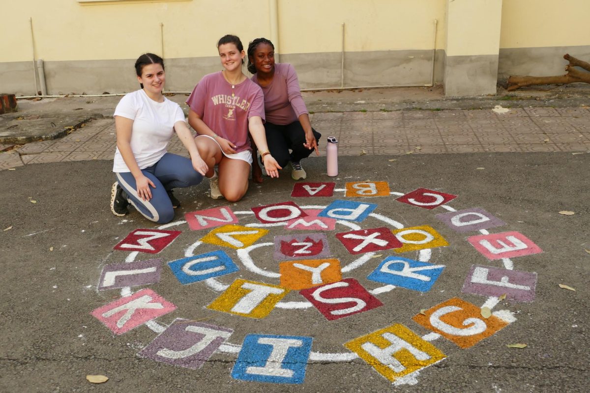 From left to right: Senior Sara Gelrud and juniors Eleonore Crepy DOrleans and Gaëlle Timmer point to the playground game they painted.