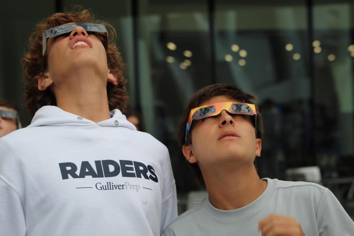 Students eagerly view the eclipse through special glasses.