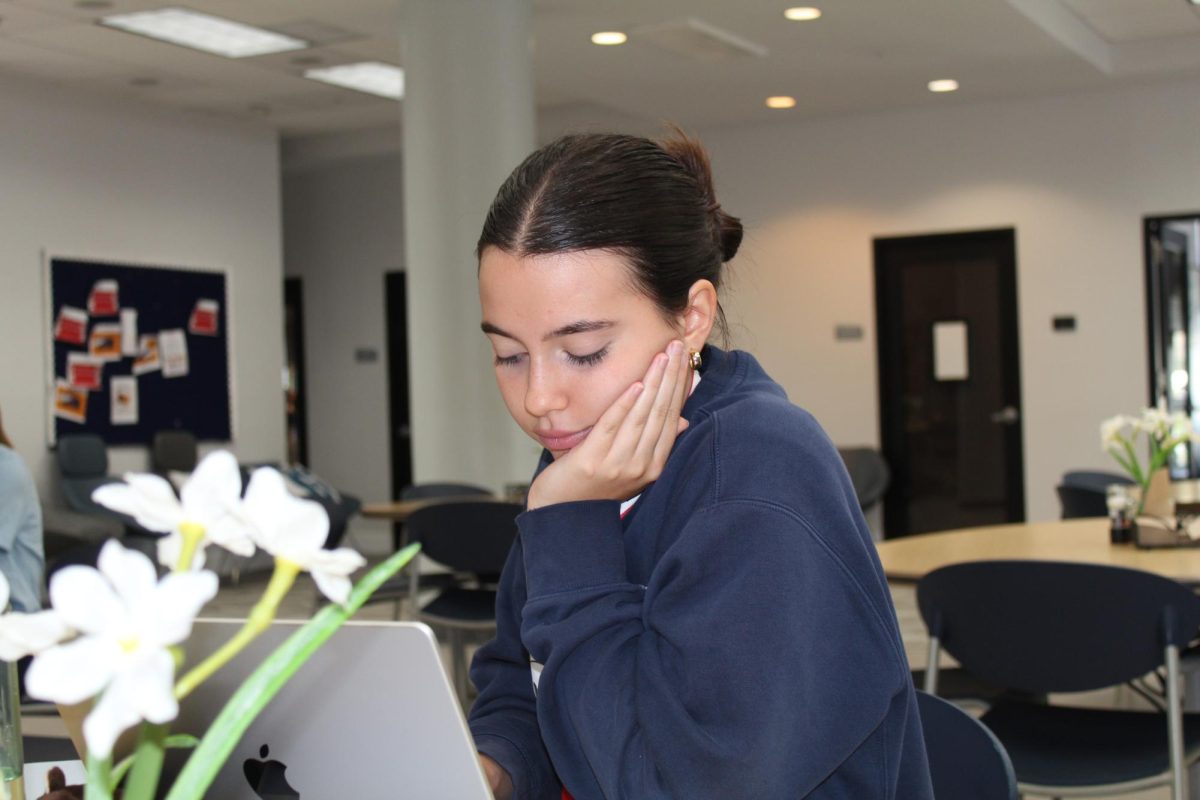 Senior Bella Burns works diligently on her supplemental essays. A widespread essay most colleges require is known as the "Why us?" essay. A student's response can show admissions officers whether a given applicant is truly enthusiastic about a college.