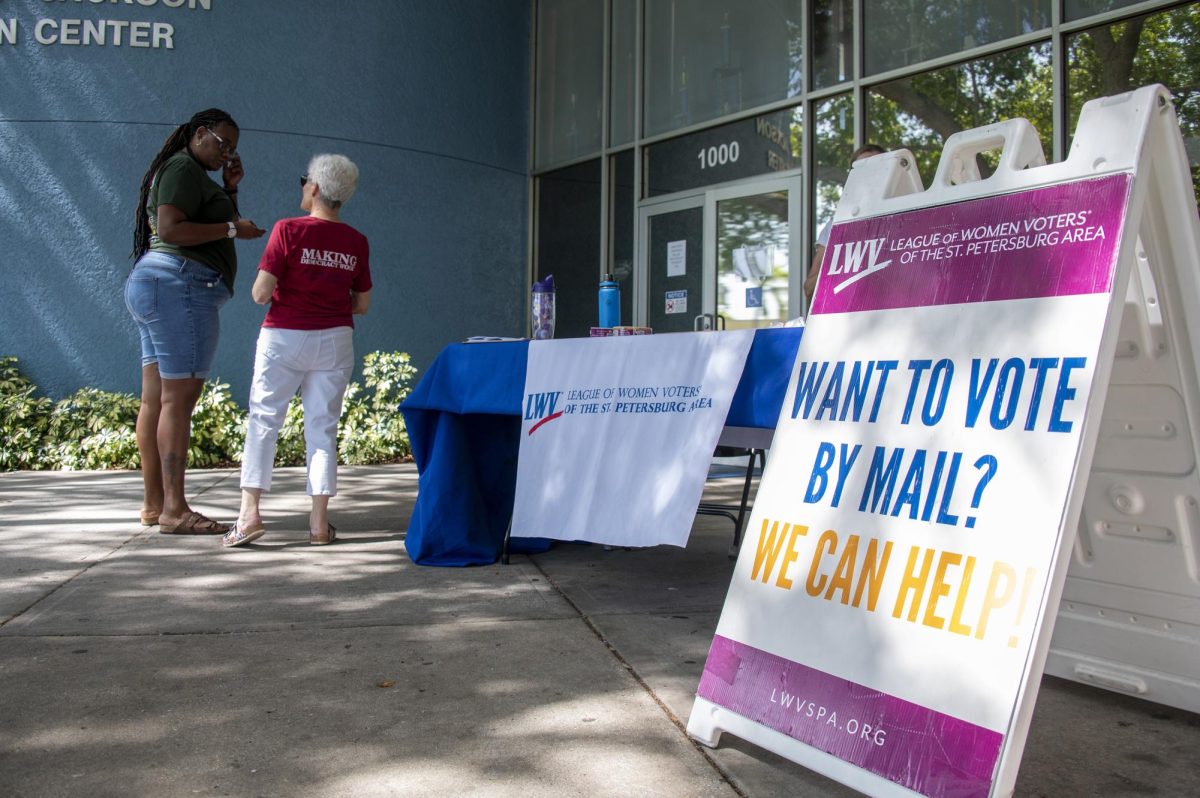 Judy Gallizzi, right, gives voter registration information to Heaven Battle outside Thomas "Jet" Jackson Recreation Center in St. Petersburg on July 25. Gallizzi is a volunteer with the League of Women Voters.