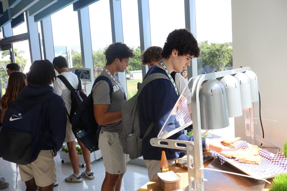 Students taking lunchtime "grab and go" items from the Raider Café. The Raider Café is a newly implemented snack and beverage shop located in the Academic Building at the Upper School Campus. SAGE, the dining service company managing the café, announced that new menu items—such as avocado toast and chicken tenders—will be sold to students and faculty starting Oct. 2.