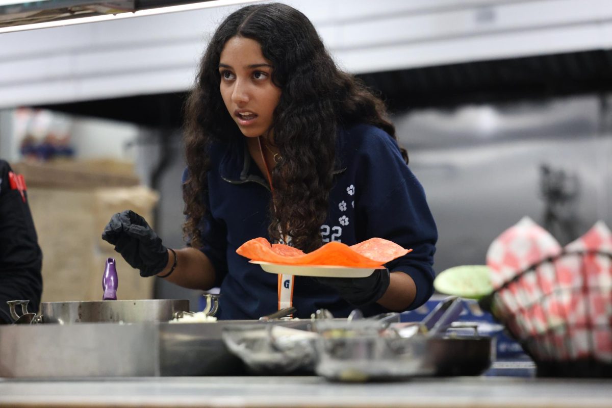 La estudiante de primer año Gianna Menjivar escucha la orden. Había una amplia gama de opciones, desde arroz hasta verduras.