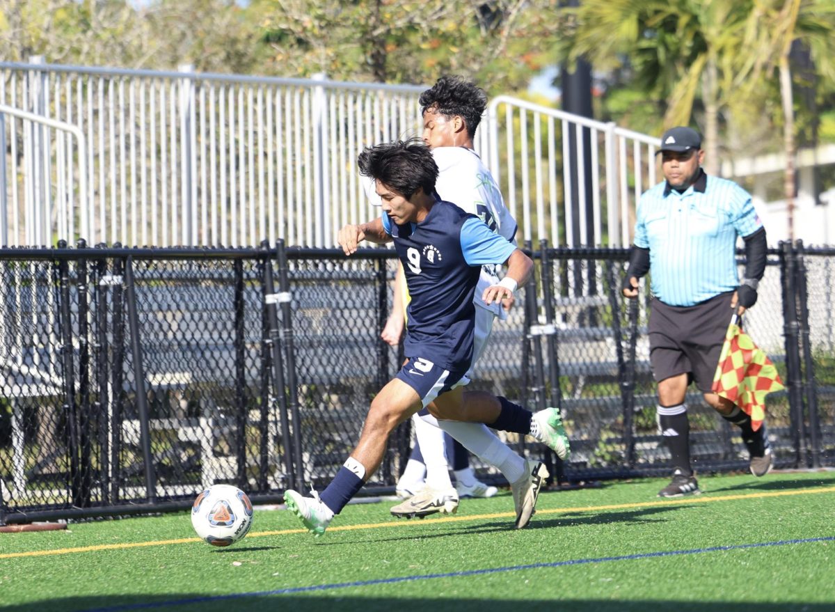 Senior forward Taro Ochi attempts to kick the ball out of bounds to stall the game. Ochi is one of the captains on the team and is trying to help lead his team back to the state finals.  