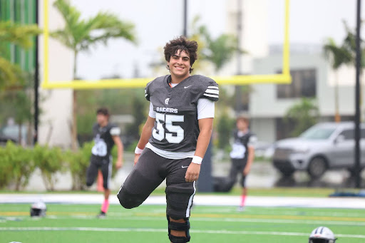 Sophomore football player Eli Levi expresses his joy stretching before heading onto the field to face Belen Jesuit. He took a deep breath, focused on the moment, and visualized his performance. 