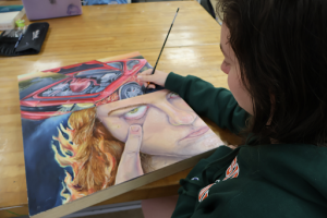  Olivia Bueno works on her art piece “Face Off”. The painting depicts the confrontations and overlap between her feminine and masculine sides. 
