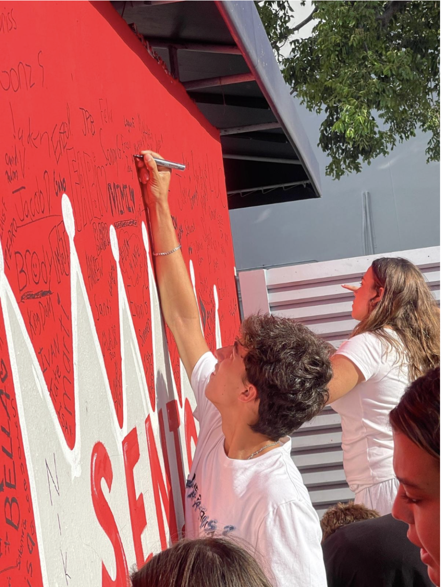 Senior Dante Cerrone signs his wall on the senior wall at senior orientation. The senior wall has been a tradition for years, marking their presence in the school for their last year. 