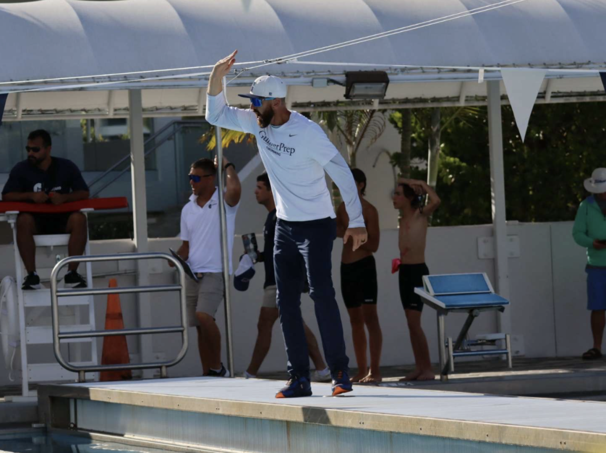 Head boys and girls coach Nick Folker hypes up the team during the meet. Folker, a former competitive swimmer, specialized in freestyle events. He won two medals at the 1999 All-Africa Games.