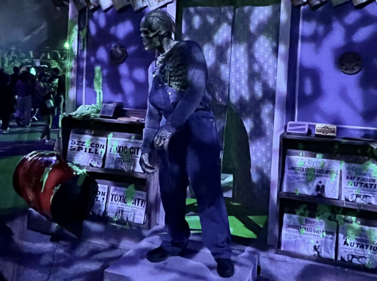 A performer dressed as a toxic mutant stands beside a glowing spill barrel in one of Halloween Horror Nights’ scare zones. The scene highlighted the attention to detail present throughout the event. It also immersed guests deeper into a world of horror, where every corner holds the potential for a new fright.