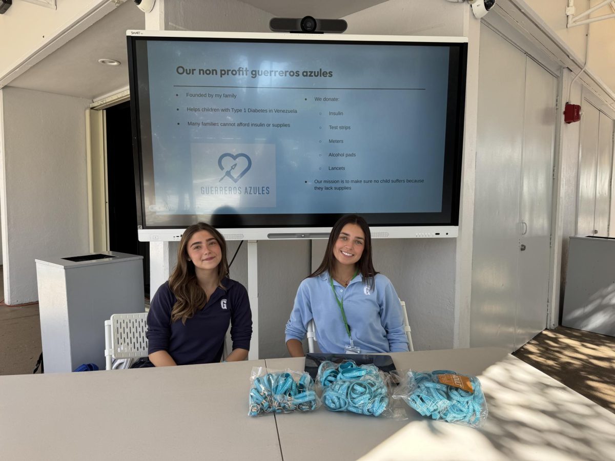 Junior Mercedes Sanz (right) and a Isabella Latham (left) sit at the Type 1 diabetes awareness booth on Nov. 18, where students learned about Guerreros Azules and the challenges faced by people living with the autoimmune disease. Guerreros Azules is the Sanz family's nonprofit supporting children with Type 1 diabetes in Venezuela.