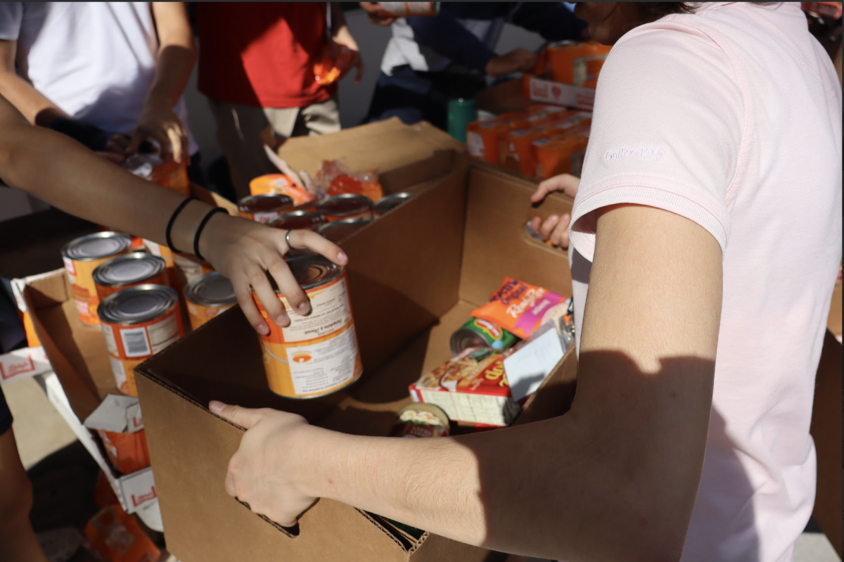 Student volunteers work together in the atrium, organizing ingredients and filling boxes with essential Thanksgiving items. Club leaders guided each station to keep the packing process efficient and ensure all 400 meals contained the necessary items.