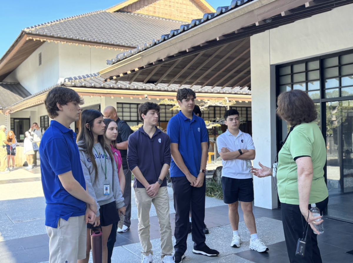 Japanese 4 Honors students explore the Morikami Museum and Japanese Gardens, learning about the history and cultural significance of traditional Japanese gardens. A museum staff member guides students through the space, explaining how its design reflects core Japanese values.
