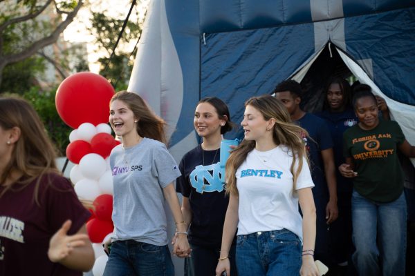 Seniors Anabelle Laemmli, Ella Rodriguez and Tate Krawiecki Gazes walk onto the field during the Senior Sunset celebration. Wearing shirts representing their future colleges, seniors celebrated the end high school while looking ahead to the next chapter of their lives.